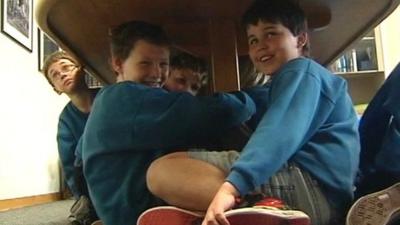 Boys sheltering under a table