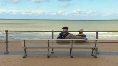 Couple on bench near sea