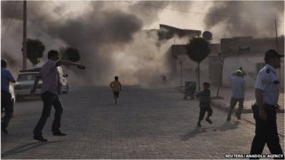 Smoke rises over the streets after a shell landed from Syria in the Turkish border village of Akcakale, south-eastern Sanliurfa province, 3 October 2012