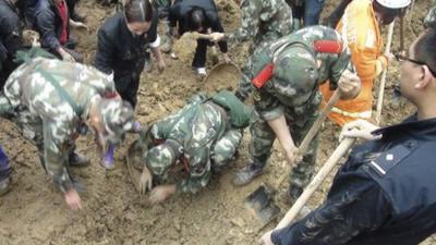 Police search for victims of the landslides in Yunnan province