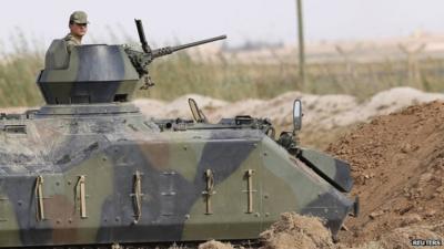 A Turkish soldier stands guard in an armoured personnel carrier on the Turkish-Syrian border near the Akcakale border crossing on 05 Oct 2012