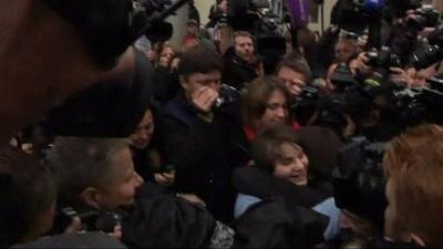 Yekaterina Samutsevich in crowd of press and supporters