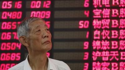 An investor looks at a stock price monitor in Shanghai