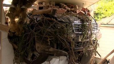 Car embedded in house