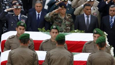 Members of the Internal Security Forces lay the coffins of slain intelligence officer Wissam al-Hassan and his bodyguard Ahmed Sahyouni