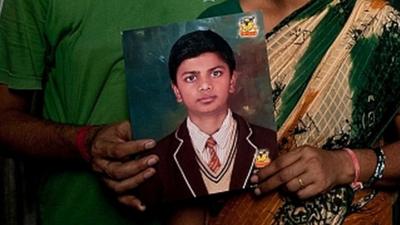 Pinki and Dinesh Kumar Singh pose with a photograph of their missing child