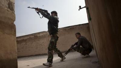 Rebel fighters fire from the roof-top of house against in the Bab el-Adid district in Aleppo on October 23