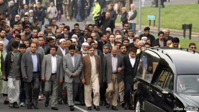 Mourners walking behind the cortege