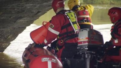 Men in boat search water