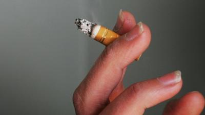 Fingers holding cigarette stub