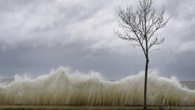 Waves come over sea wall on Long Island, New York