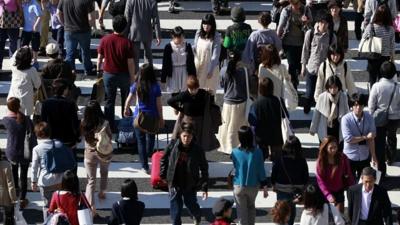 People cross a street in Tokyo's Harajuku shopping district