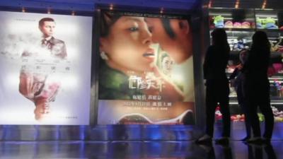 People at a Chinese cinema, looking at posters