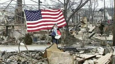 Woman stands among rubble after Storm Sandy hit