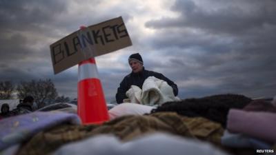 A victim of Storm Sandy takes blankets from a aid distribution site in Staten Island