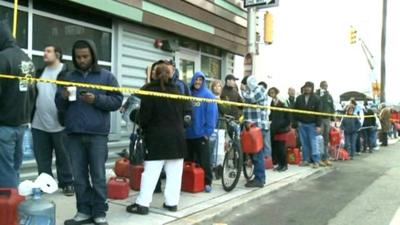 People wait in a queue to buy petrol