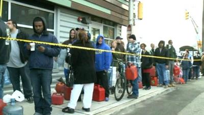 People wait in a queue to buy petrol