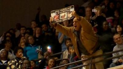 Man shouting and holding placard