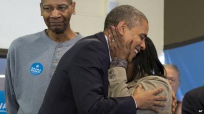 President Barack Obama is embraced by a volunteer as he visits a campaign office the morning of the 2012 electio