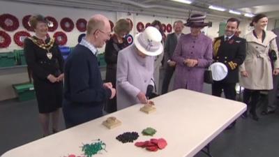 The Queen making a poppy at the Poppy Factory in Richmond