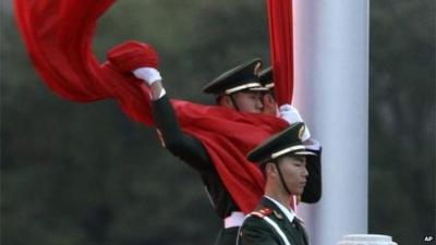 Chinese policeman holding flag in Tiananmen Square