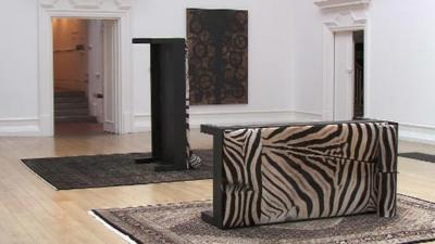 Two couch beds at unusual angles on rugs - part of Rashid Johnson's exhibition