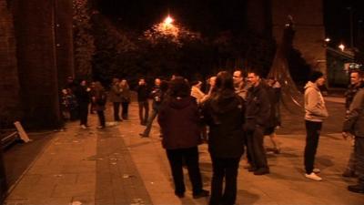 People standing on a street at night