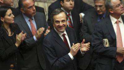 Greece"s Prime Minister Antonis Samaras and his party's lawmakers of the New Democracy applaud after voting on the country's 2013 budget