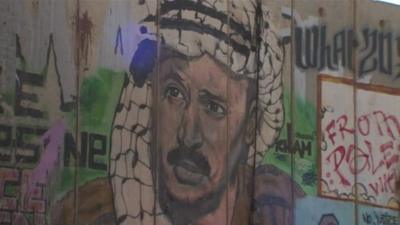 Graffiti images of Yasser Arafat have been sprayed across blast walls