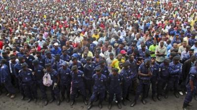 Congo government policemen, foreground, and civilians gather during a M23 rally in Goma, DR Congo