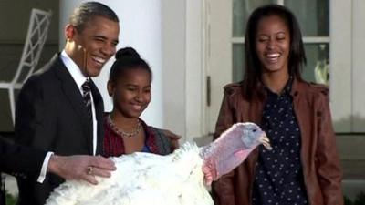 Barack Obama and his daughters with a turkey