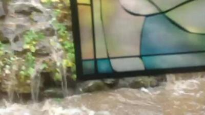 Stain-glass window surrounded by flood waters