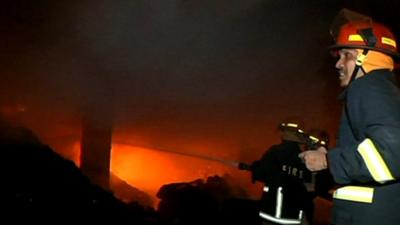 Firefighter tries to dampen the flames of the fire outside Dhaka