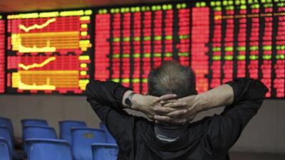 An investor in front of an electronic stock indicator board in Hefei, Anhui province