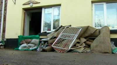 Damaged carpet and possessions outside house