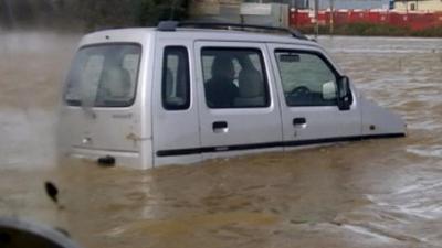 Car driver trapped in flood water