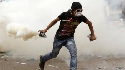 Protester holding a teargas canister