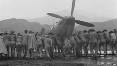 Men push spitfire along ground