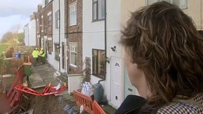 One of the home owners looks at the landslide