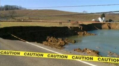 Sinkhole affecting road and nearby house