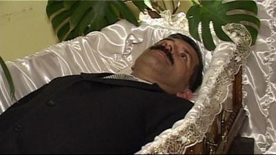 Man lying in coffin