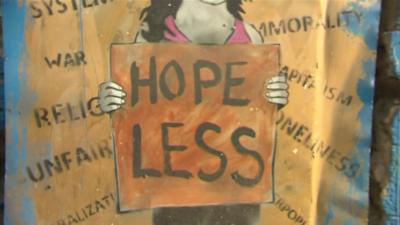 Street art: Girl holding "Hope Less" sign