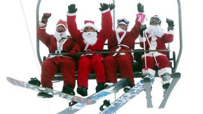 People dressed as Santa on a ski lift.