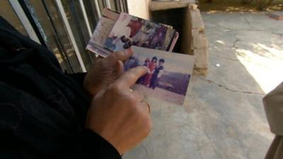 Woman holding photos of relatives killed during gas attack in Halabja