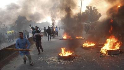 Activists of Bangladesh's Jamaat-e-Islami party set fire to tyres as they block a street in Narayanganj