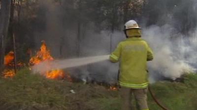 A firefighter tackles a bushfire near Brisbane