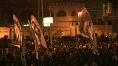 Protestors wave flags outside presidential palace in Cairo