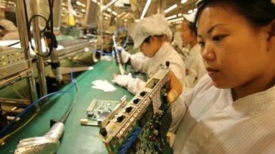 Factory worker checks component