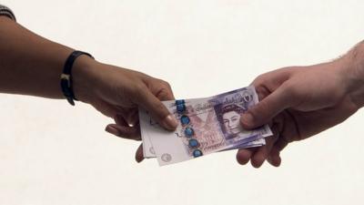 Handing over £20 notes