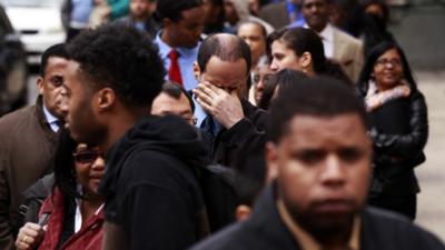 A man rubs his eyes as he waits in a line of jobseekers at a career fair in New York on 12 April 2012